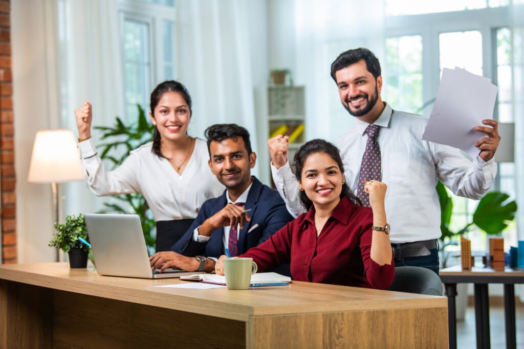 Young Indian asian leader coach teaching employees group analyzing online project explaining business strategy speaking training diverse corporate team with laptop using computer at office meeting